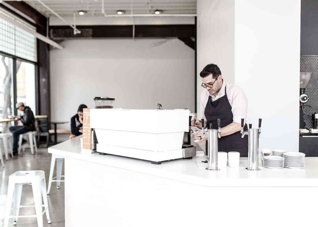 Image of a barrista working at a cappucino machine